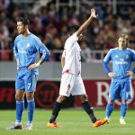 Sevilla's Sevilla's Carlos Bacca celebrates between Real Madrid's Cristiano Ronaldo and Luka Modric during their soccer match in Seville