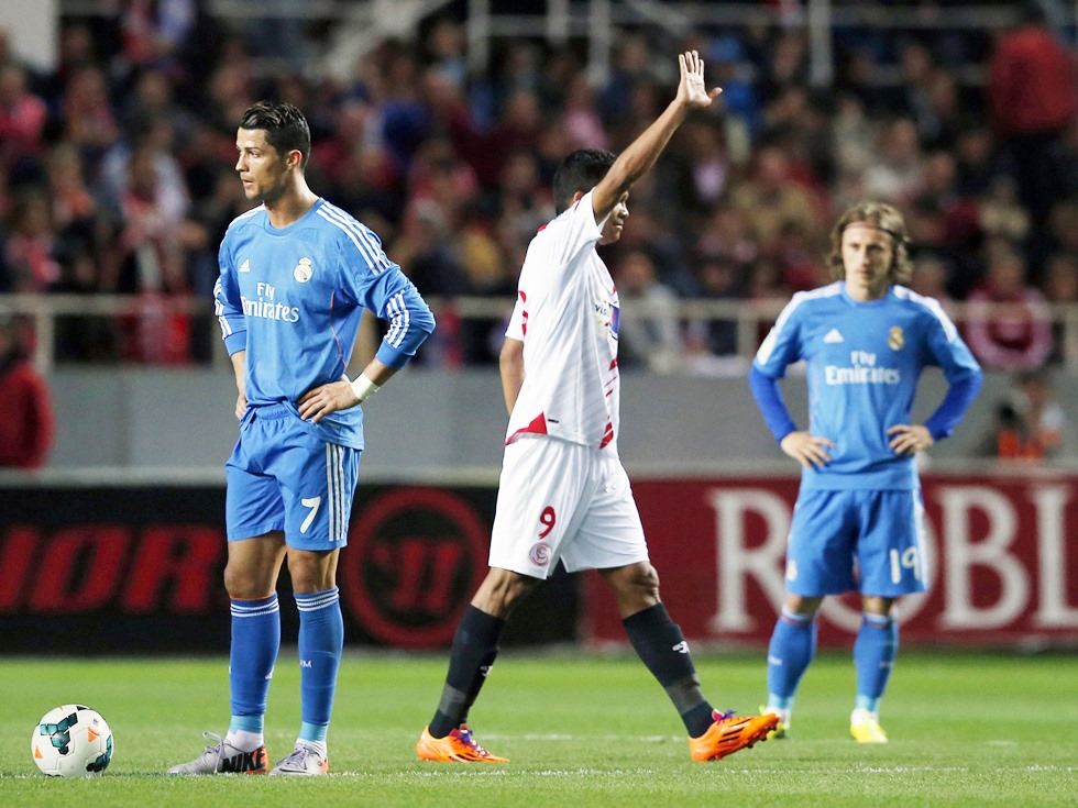 Sevilla's Sevilla's Carlos Bacca celebrates between Real Madrid's Cristiano Ronaldo and Luka Modric during their soccer match in Seville